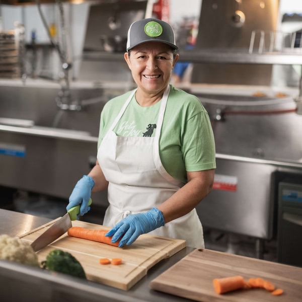 A Get Joy team member chopping fresh carrots